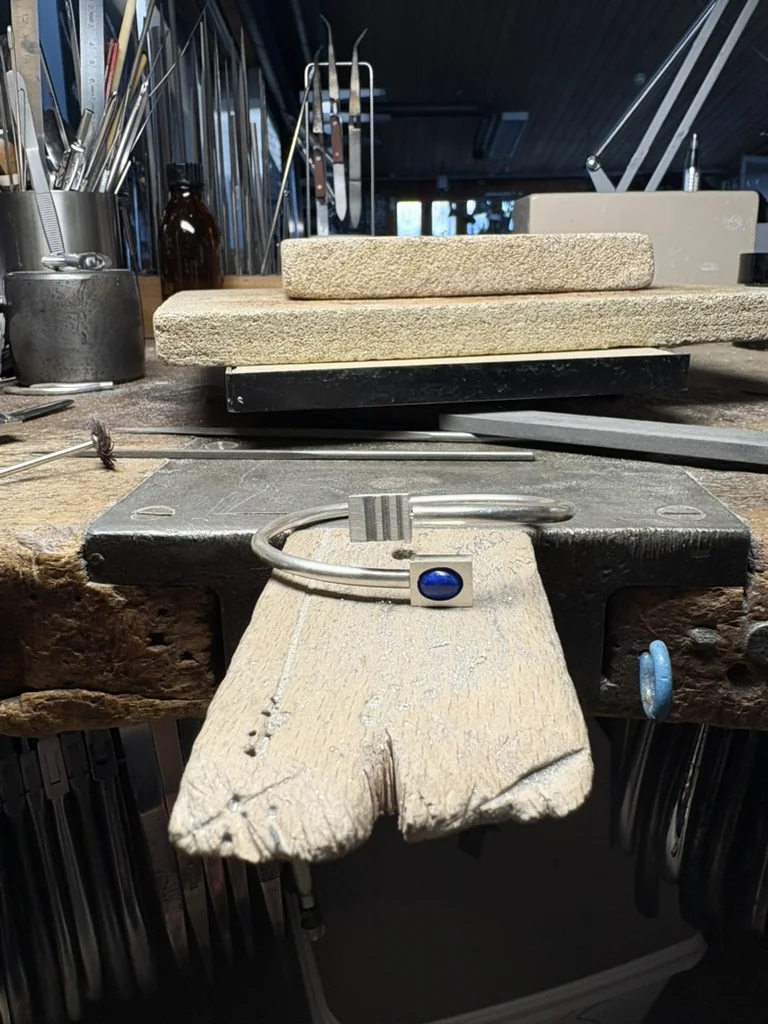 Bracelet with the lapis lazuli stone set, resting on a leather bench block