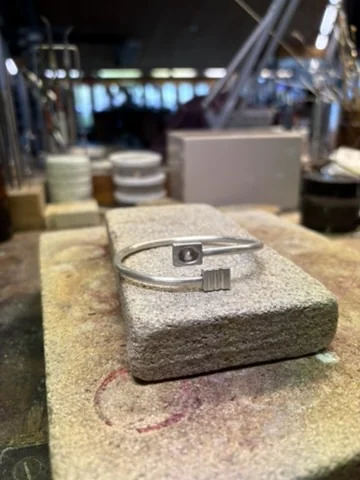Silver bangle with textured clasp piece on the workbench