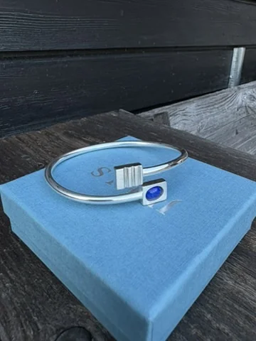 Finished silver and lapis lazuli bracelet resting on its gift box