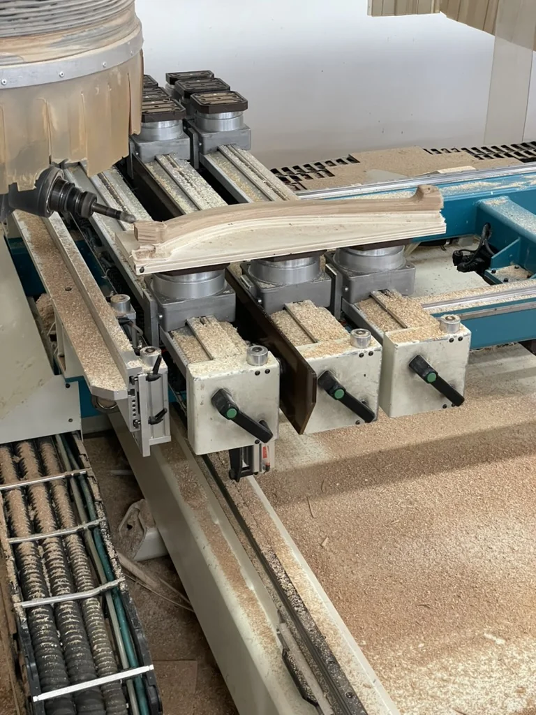 Finished CNC-cut wood leg on the machine bed