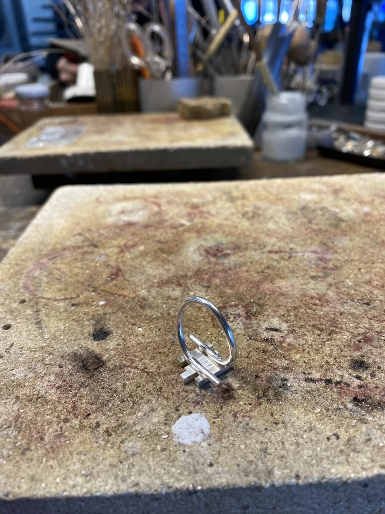 Unfinished silver ring standing on a soldering block